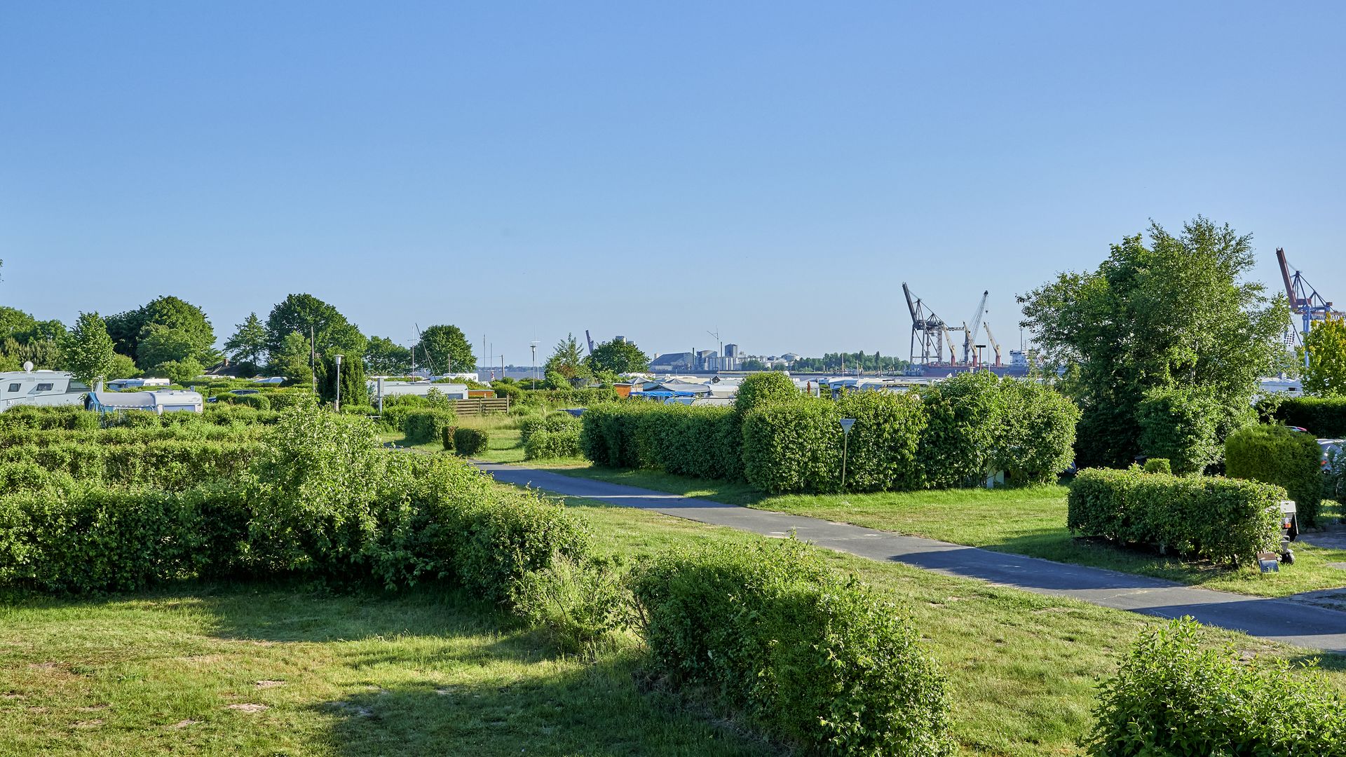 Blick über den Campingplatz Richtung Wasser und den gegenüberliegenden Hafen.